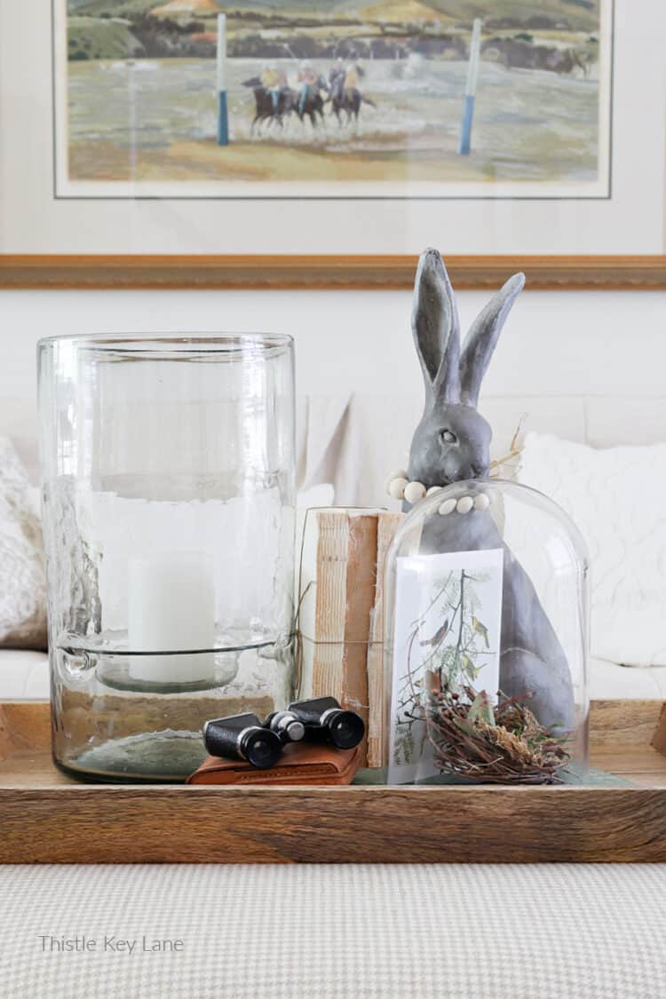 Hurricane candle holder, books, a rabbit and cloche. 