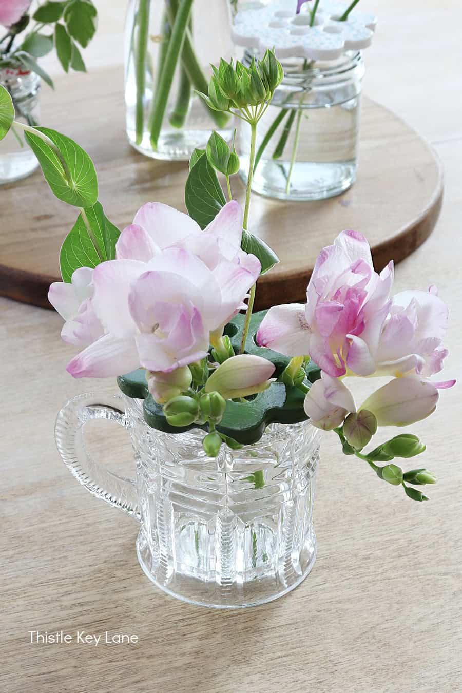 Green flower frog, pink freesia in a glass cup. DIY Air Dry Clay Flower Frogs.