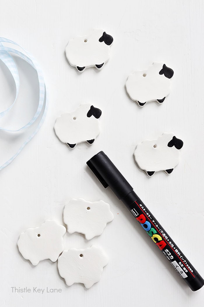 Using a marker to add details on clay sheep.