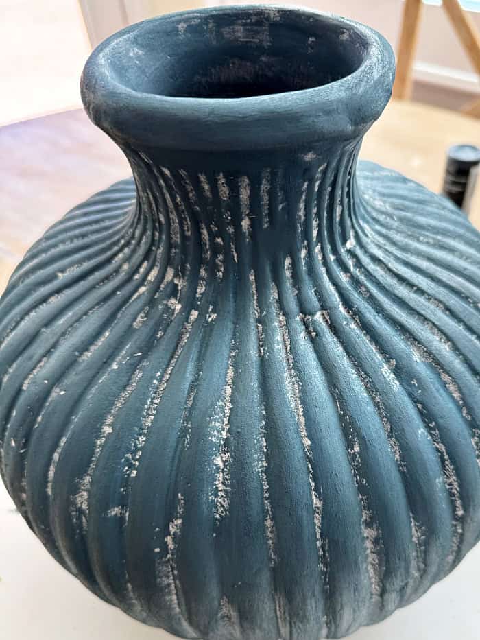 Covering vase with textured paint.