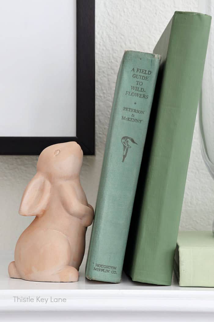 Clay rabbit with green books. Vintage Spring Mantel Decor Styling.