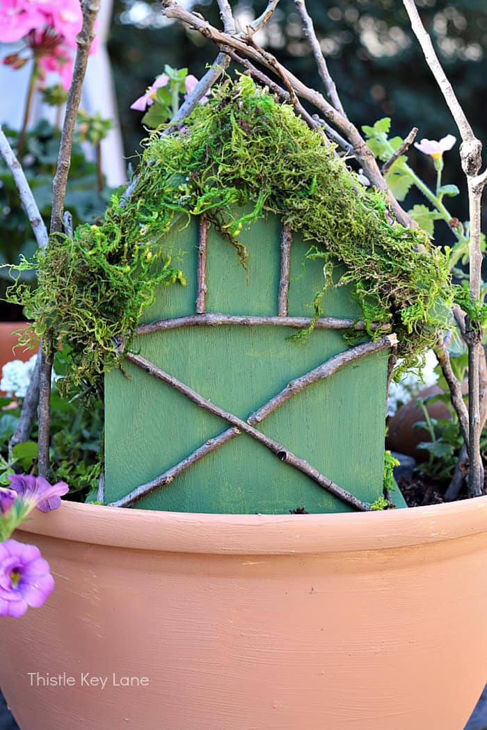 Back of fairy house with moss and twigs. How To Make A Flower Pot Fairy Garden.