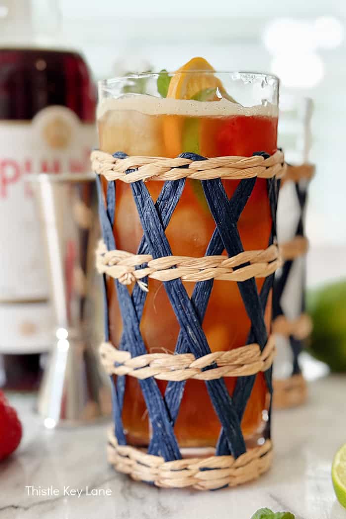 Cocktail with lemon lime and strawberry garnish.