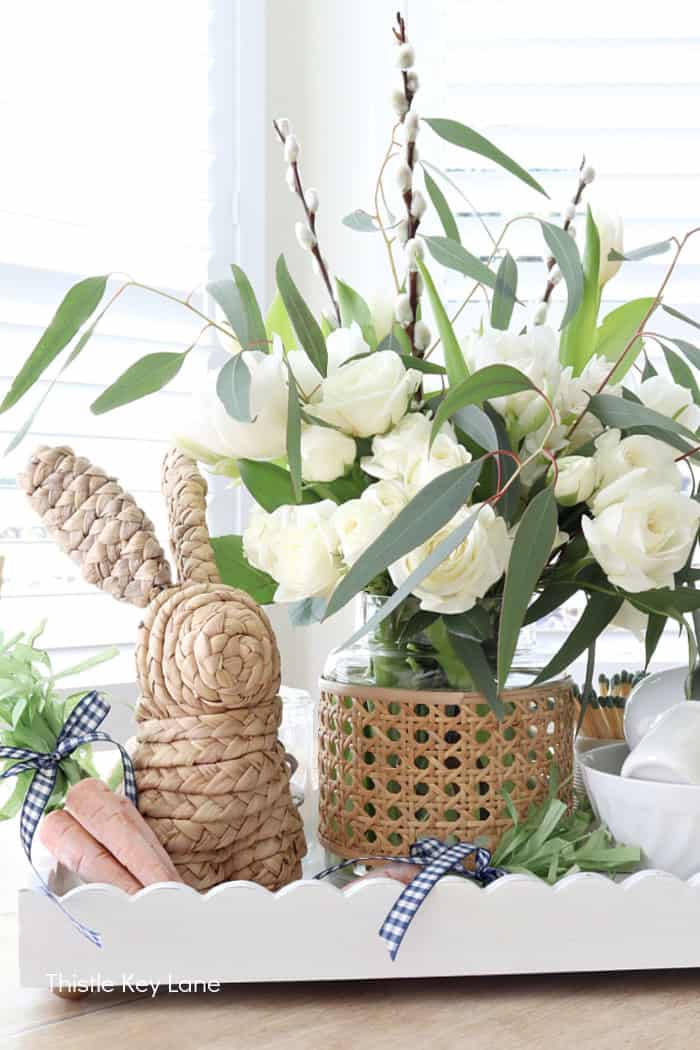 Woven bunny and wicker vase holding flowers. Spring Tray Flower Centerpiece.