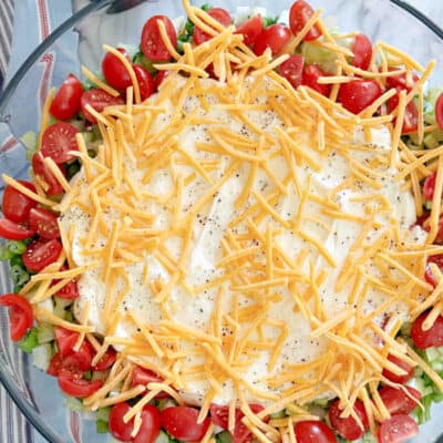 Mayo dressing and cheese on top of salad. Green Pea Layered Salad Recipe.