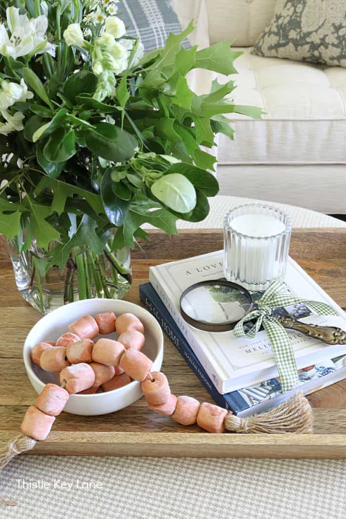A tray with books, flowers and a vase. ottoman. Summer Fresh Ottoman Styling.