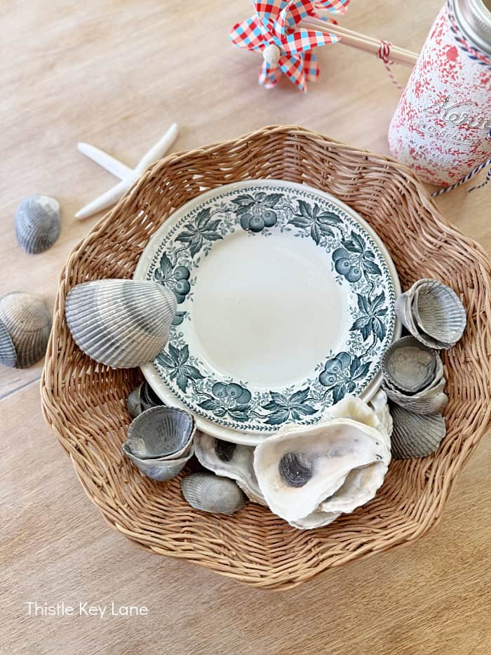 Plates in a basket surrounded by shells.