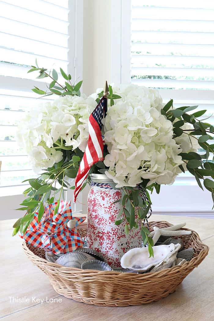 Flags mixed with white hydrangeas. Summer Red White And Blue Centerpiece.