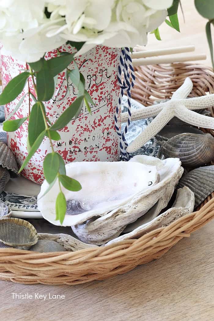 Oyster shells and sea star in a basket arrangement. Summer Red White And Blue Centerpiece.