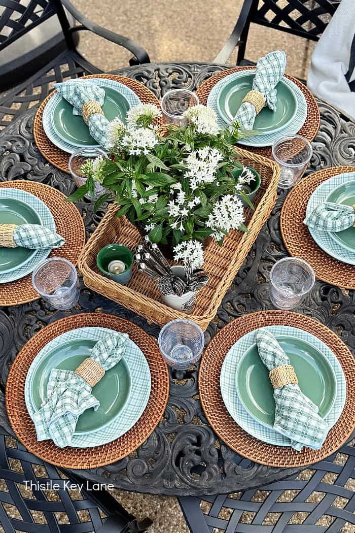 View of outdoor tablescape with white flowers. Breezy Summer Patio Tour.