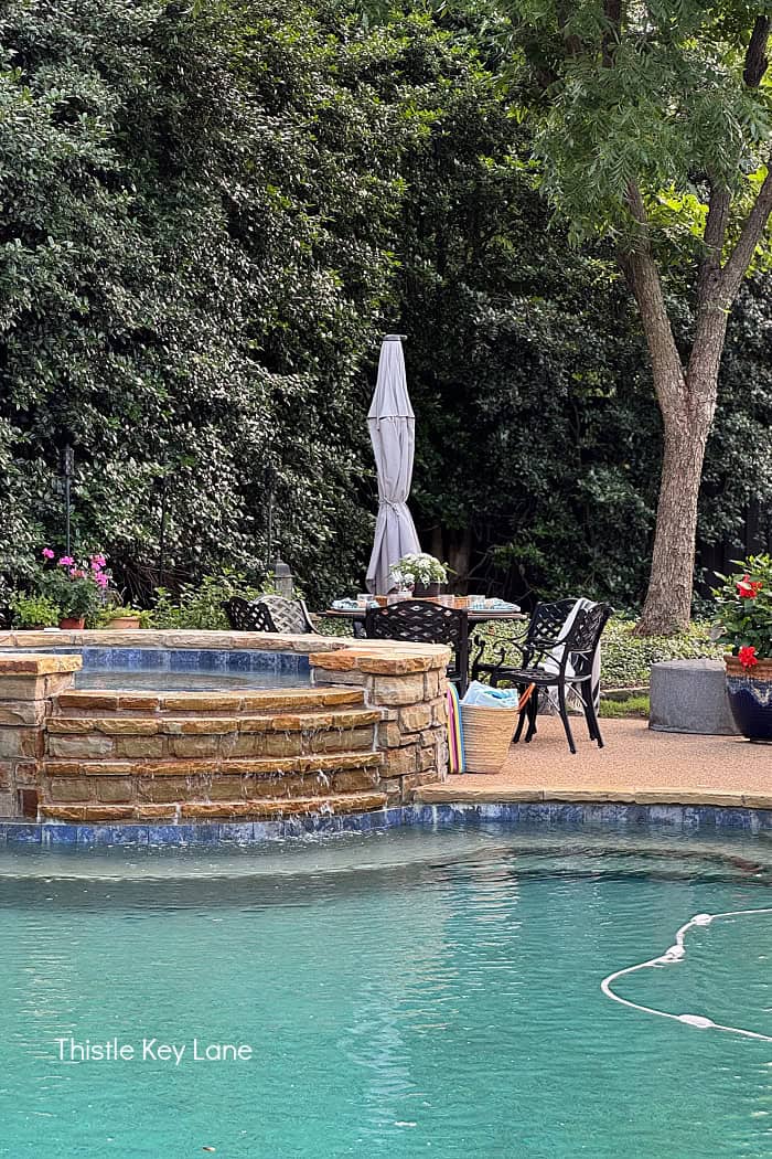 A pool with spa and a patio area. Breezy Summer Patio Tour.