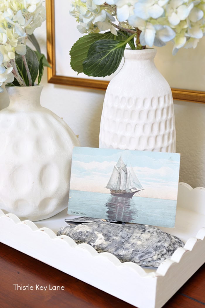 White vases and a vintage sailboat postcard. Coastal Cottage Entry Table.