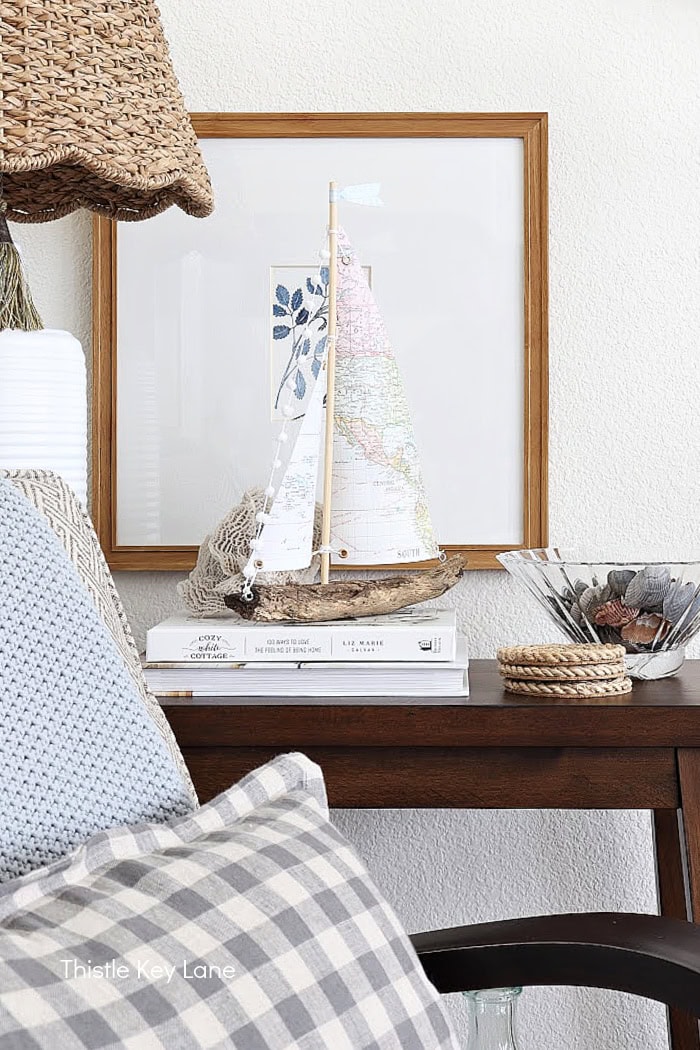 Table with books, coasters, shells and a sailboat. How To Make A Map Sailboat.