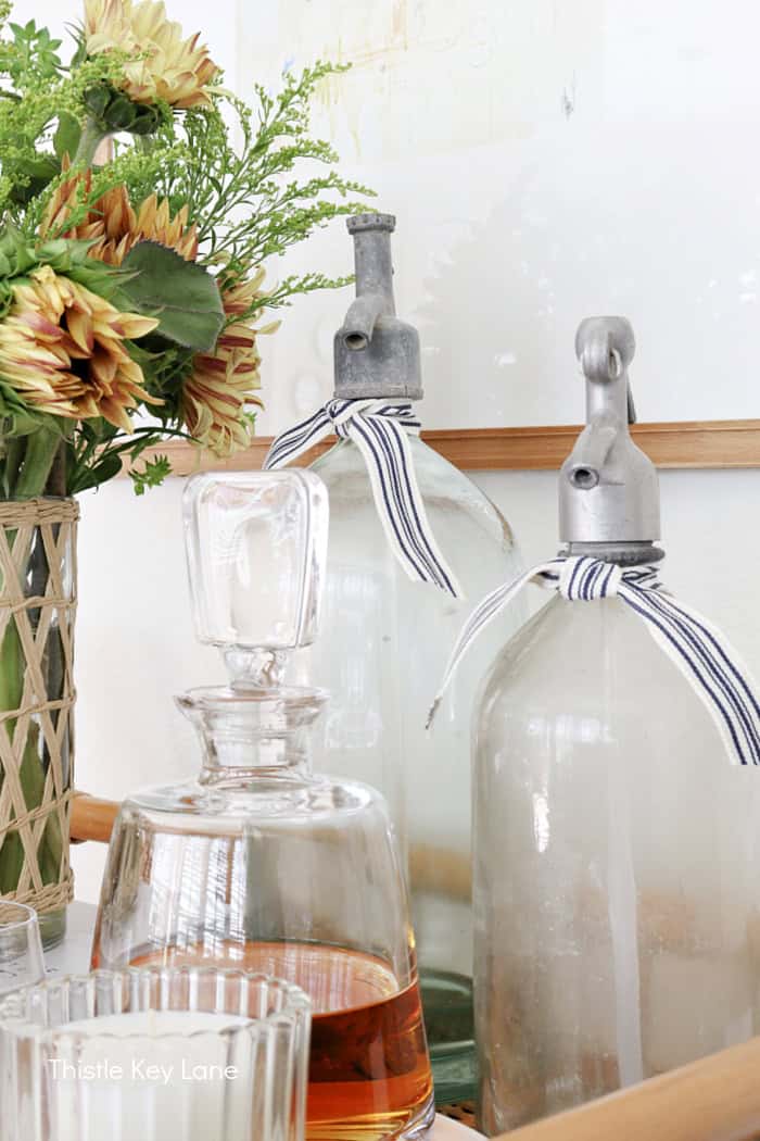 Vintage seltzer bottles. Summer To Fall Bar Cart With Sunflowers.