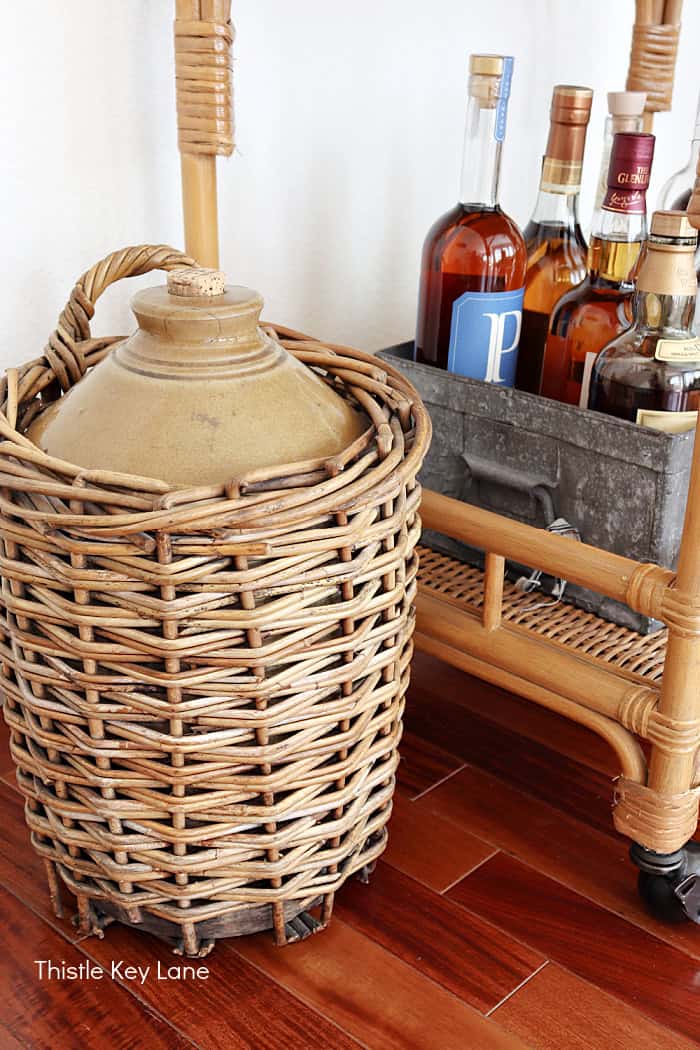 Wicker stoneware bottle. Summer To Fall Bar Cart With Sunflowers.