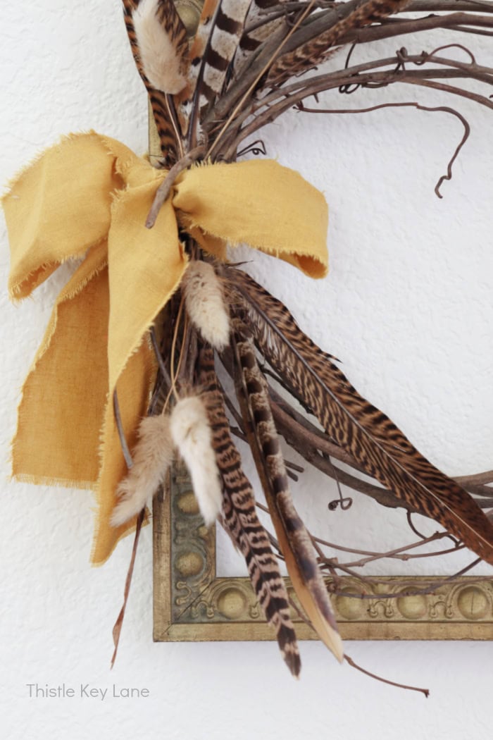 View of feathers and dried florals on wreath.