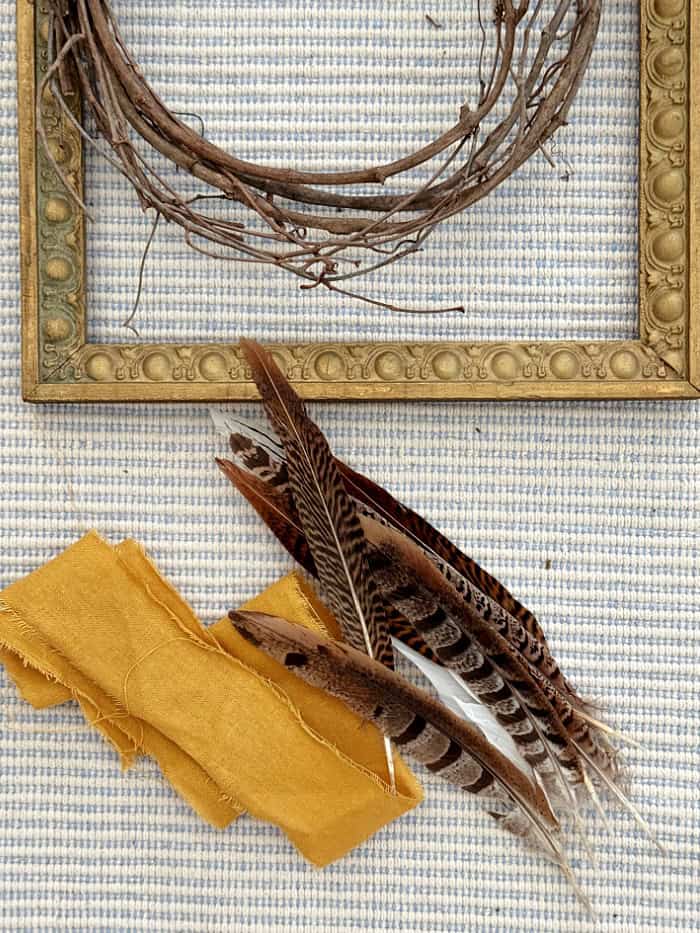 Supplies to make a frame grapevine with feathers and ribbon. DIY Vintage Frame Wreath With Feathers.