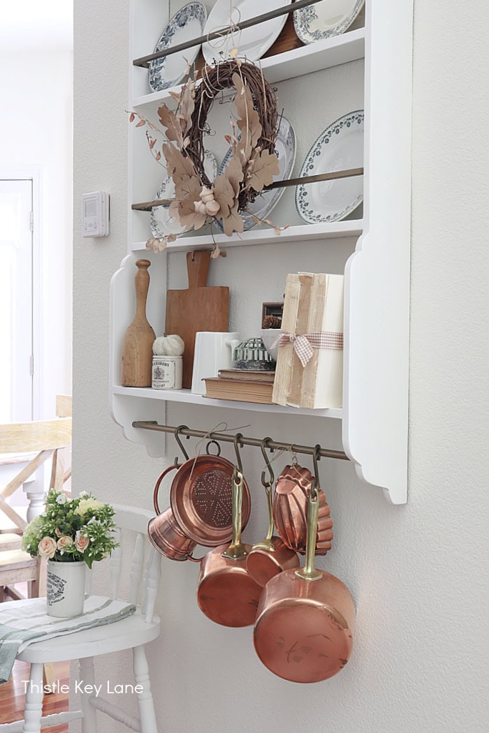 Books, bread board, copper pots. Early Fall Plate Rack Styling.