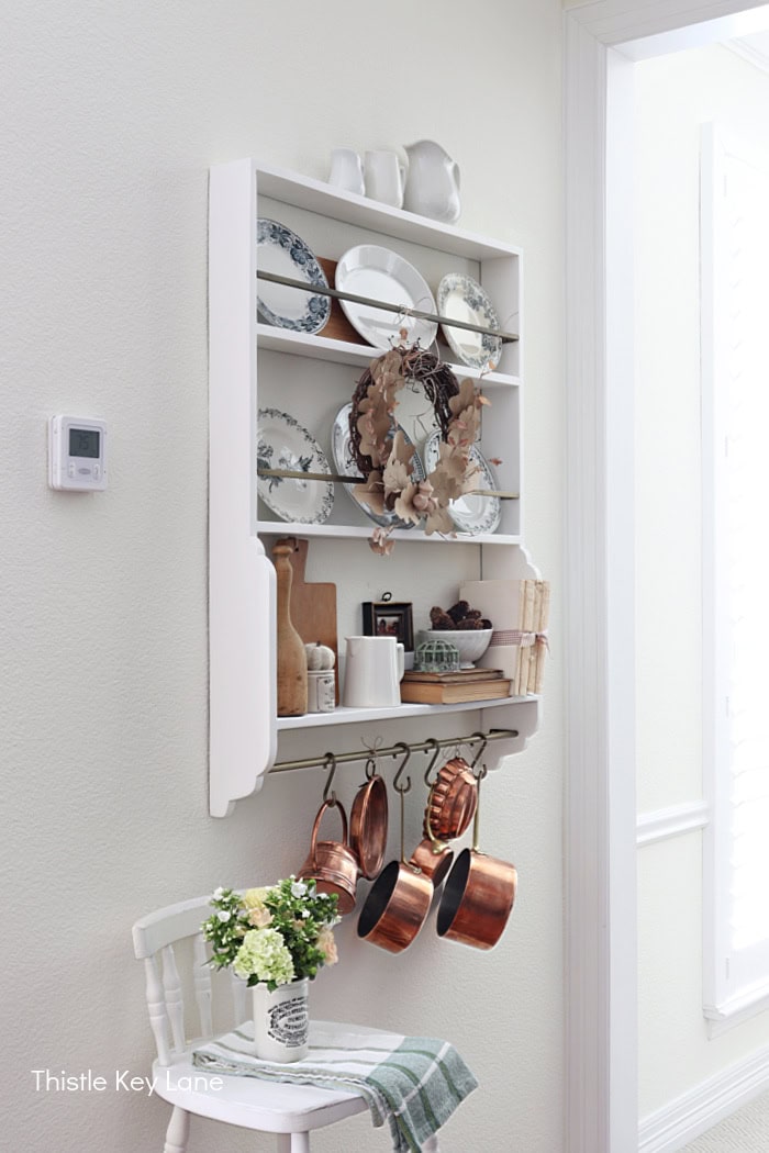 Collection of French blue and white transferware plates, wreath and copper pots. Early Fall Plate Rack Styling.