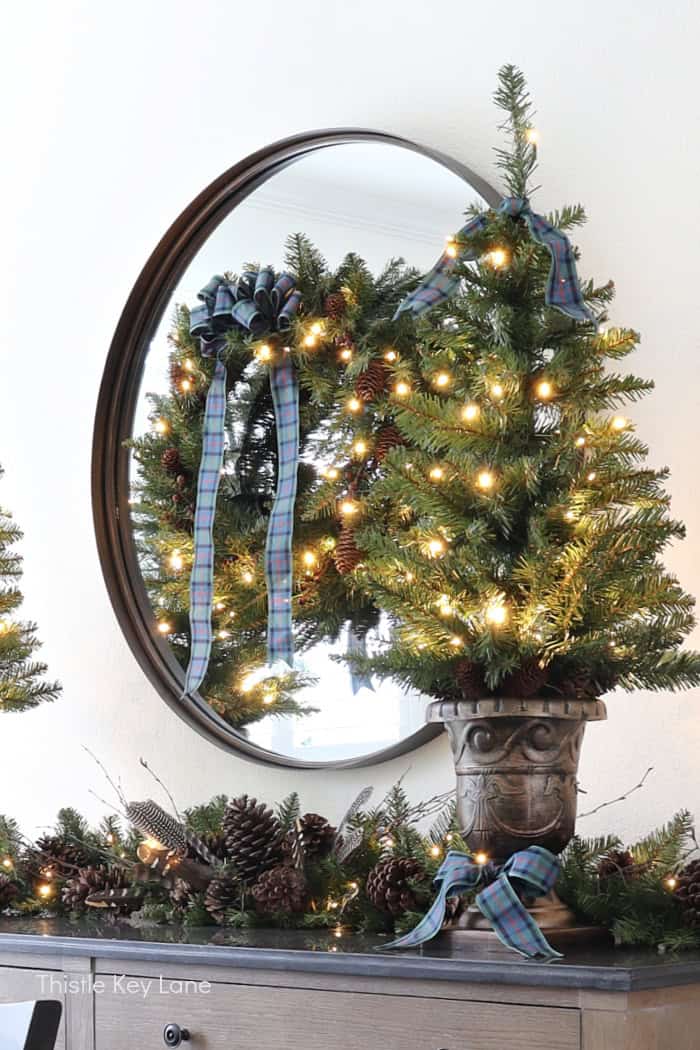 Mini Christmas tree in an urn with plaid bow. Easy Plan Ahead Christmas Decorating.
