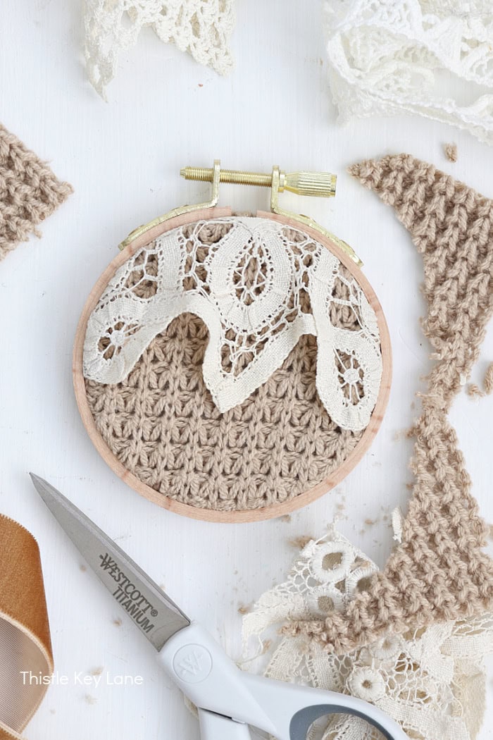 Delicate lace embroidery on crochet fabric, craftsmanship and textile art. Embroidery Hoop Ornaments From Sweaters.