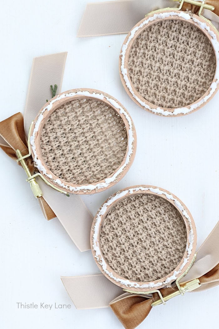 Adding glue on the embroidery hoop backs.