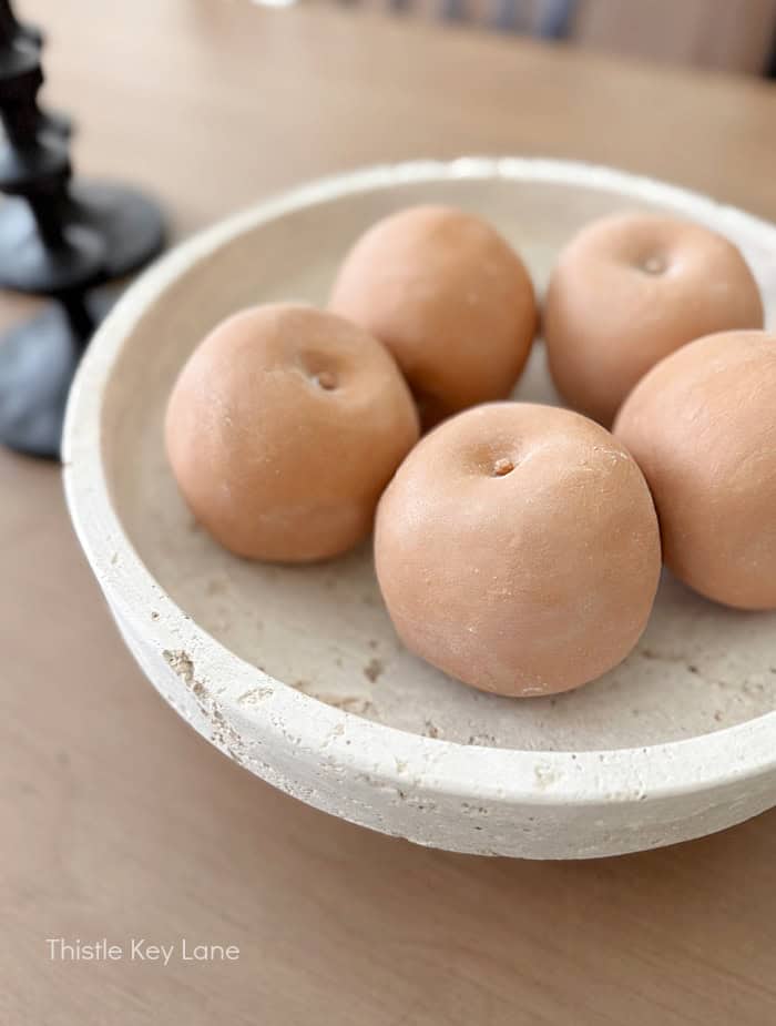 Stone bowl with terra cotta apples.