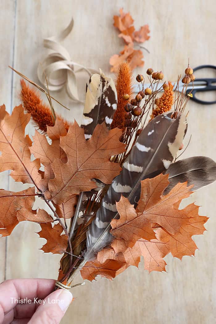 Leaves and feathers in a dried floral bouquet.
