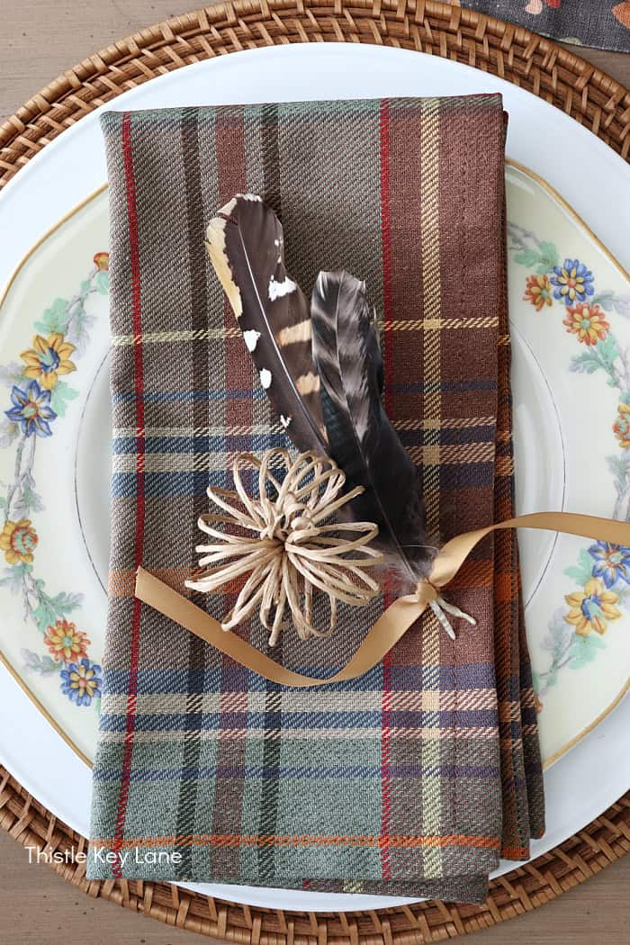 Plaid napkin, feathers, ribbon, wire pumpkin.