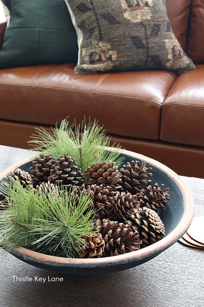 Blue terra cotta bowl with pinecones and greenery.