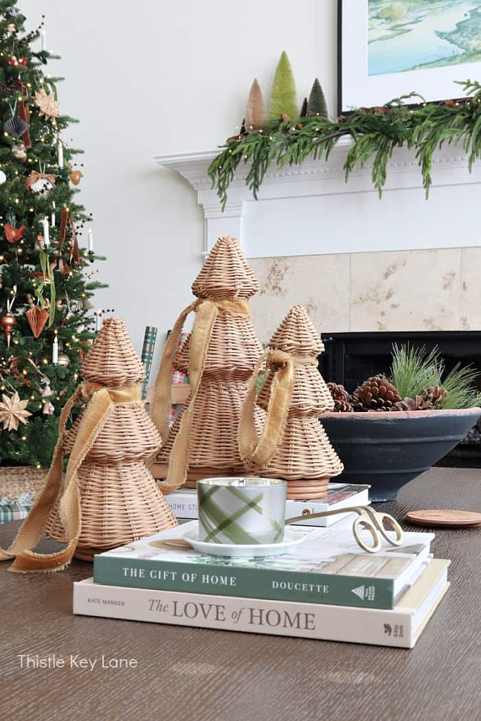 Wicker trees with ribbon on books. Country Cottage Christmas Home Tour.