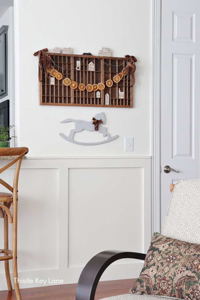 Printers drawer on the wall with orange slice garland. Country Cottage Christmas Home Tour.