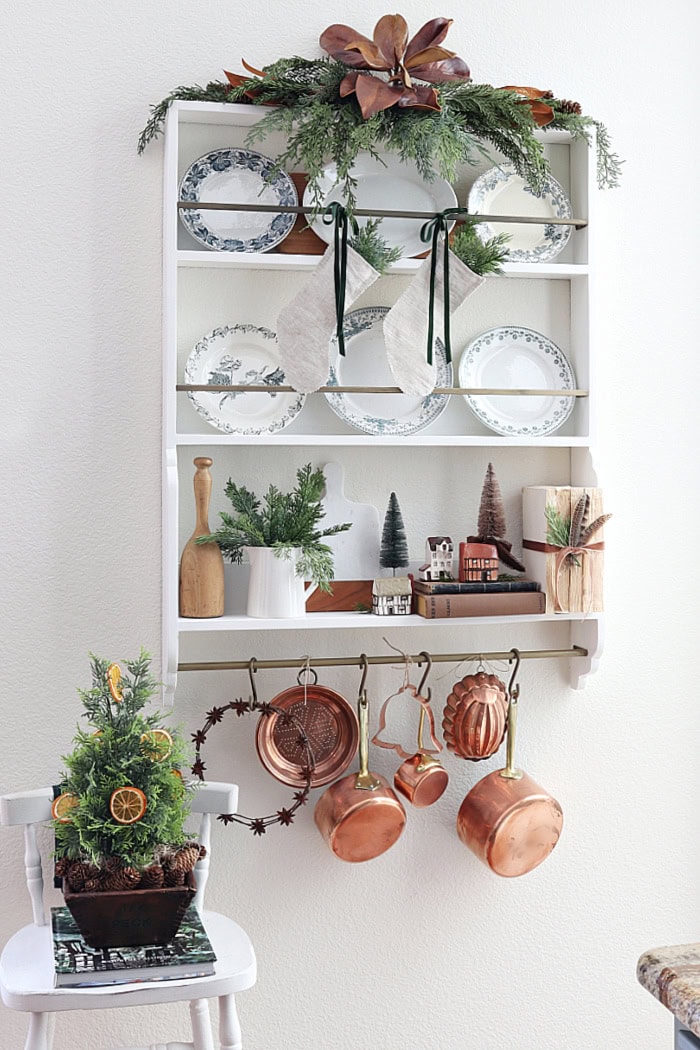 Full view of plate rack with holiday decorations and copper pots. How To Decorate With Homemade Stockings.