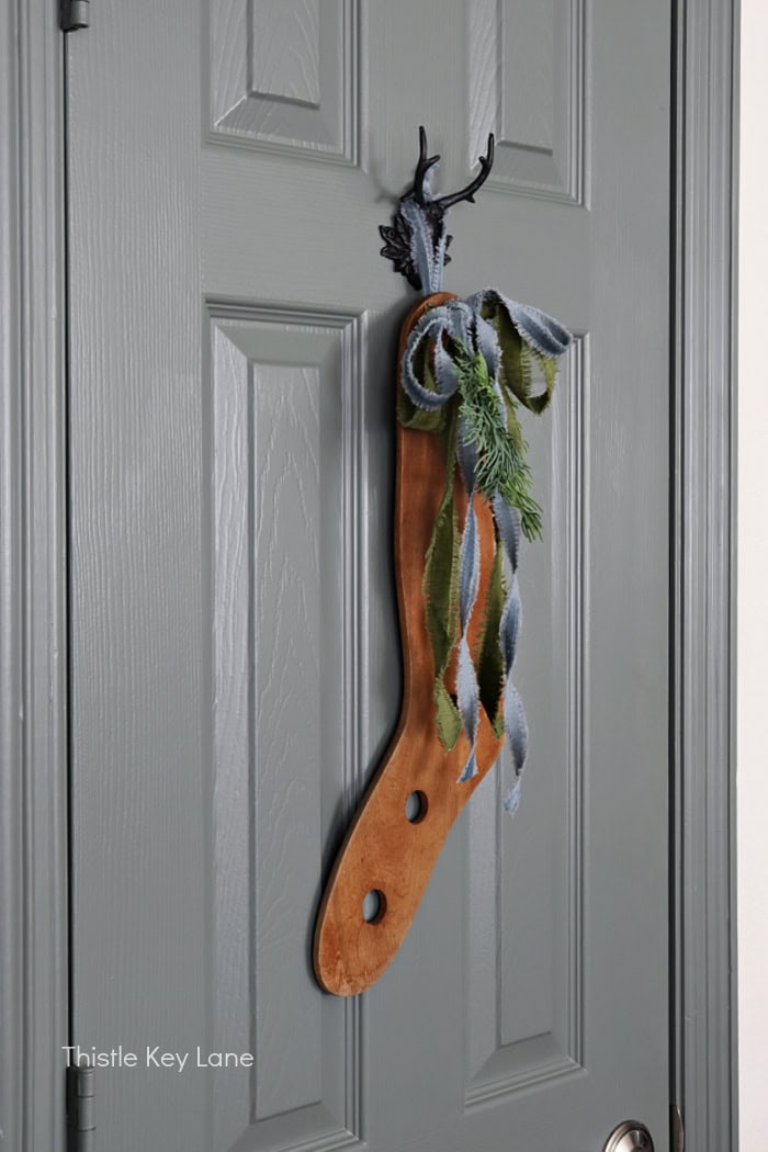 Stag hook on a door with a wood stocking stretcher. Simple Vintage Holiday Kitchen Ideas.