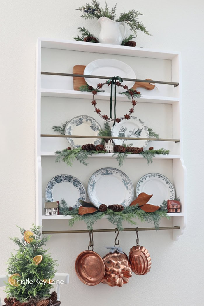 Copper molds hanging from a plate rack. Simple Vintage Holiday Kitchen Ideas.