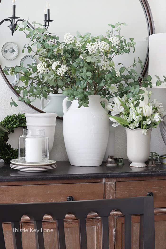 Eclectic grouping of vases. Floral Spring Vignette For Buffet Or Sideboard.