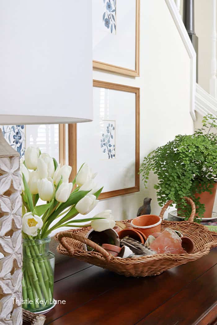 Spring entry table with basket, tulips and a fern. How To Create A Garden Basket Vignette.