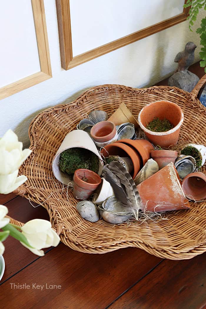 Scalloped basket with little terra cotta flower pots. How To Create A Garden Basket Vignette.