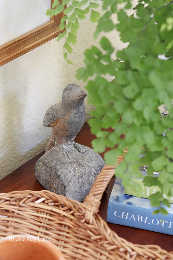 Bird figure tucked in behind a fern.