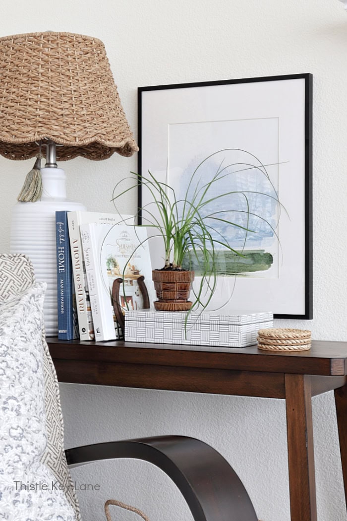 Decorative plant and box on console table with artwork in the background. Winter To Spring Transitional Styling.