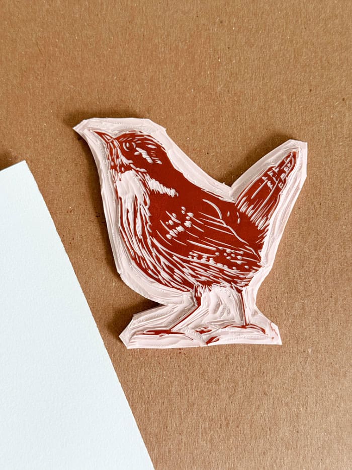 Applying brown ink to bird block for printing. How To Make Block Print Art.
