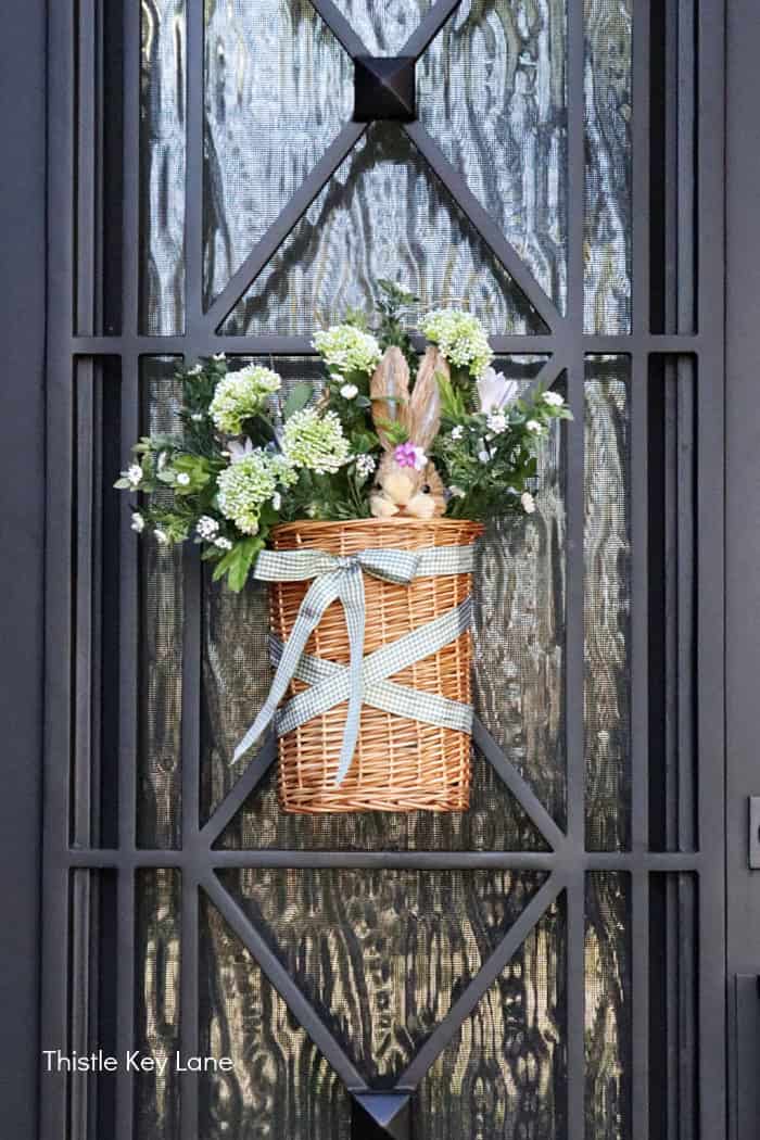 Bunny pick mixed in the flowers in a basket. Spring Porch Refresh With Bunnies.