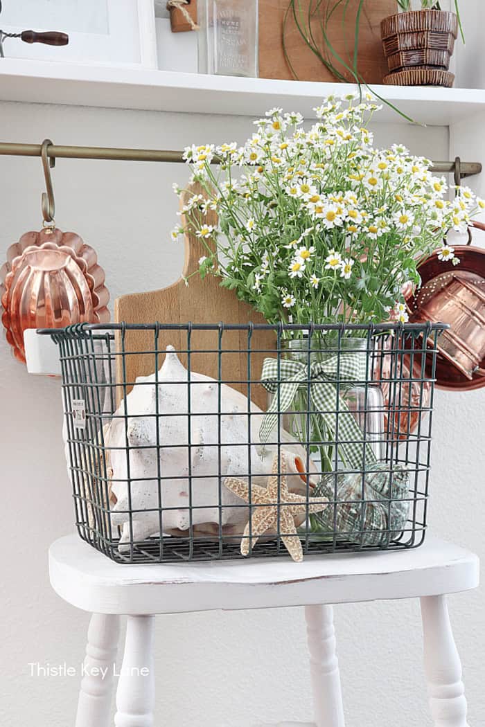 Vintage locker basket flowers and large shell. How To Decorate With A Wire Basket.