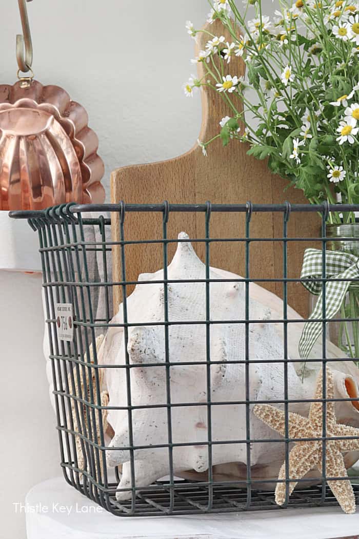 Wood bread board, basket and shell. How To Decorate With A Wire Basket.