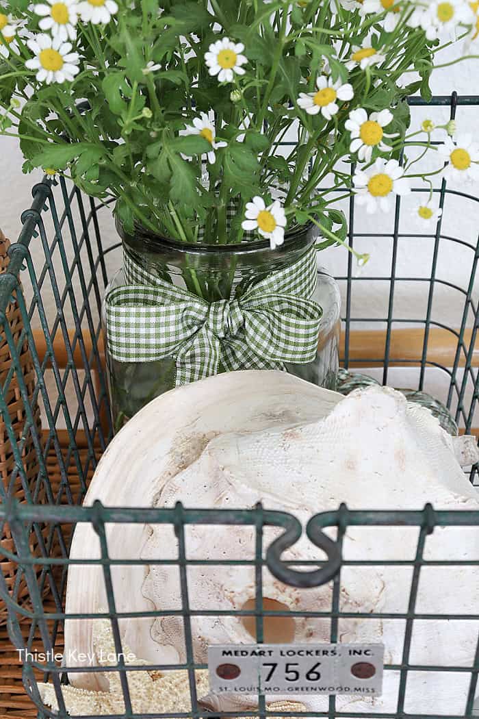Green gingham ribbon on a jar of flowers. How To Decorate With A Wire Basket.