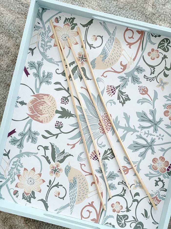 Adding square dowels as trim to a tray. How To Decorate A Tray With Wallpaper.