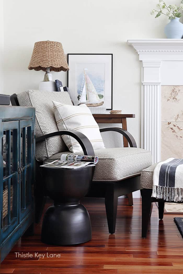 Arm chair in a corner with table, lamp and artwork. Coastal Family Room Styling.