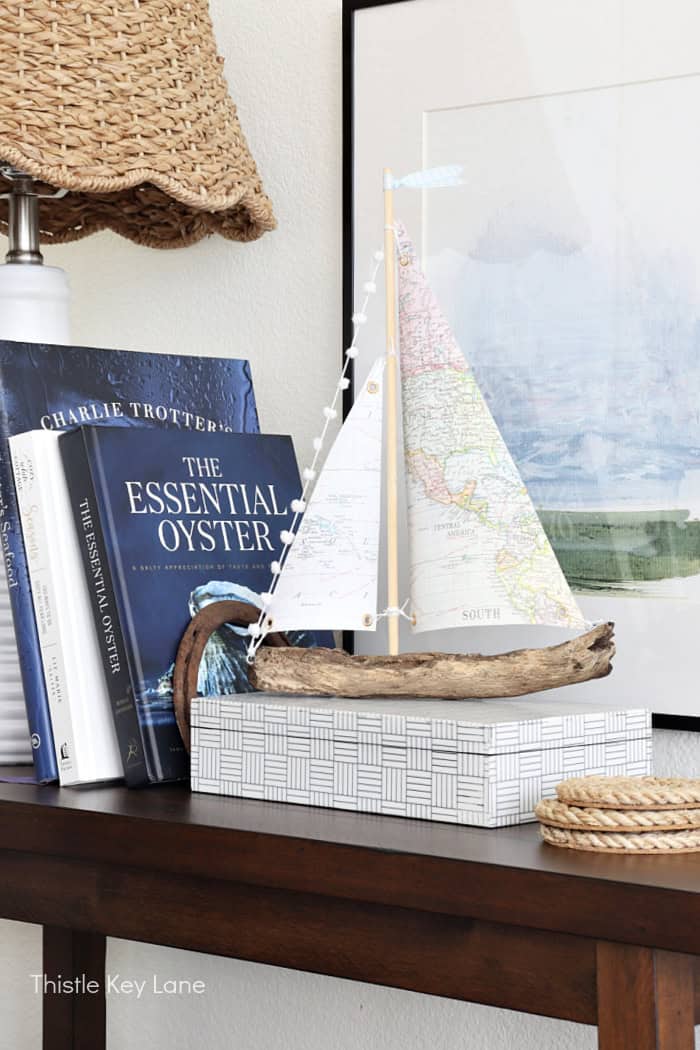 Map sailboat, books and artwork. Coastal Family Room Styling.
