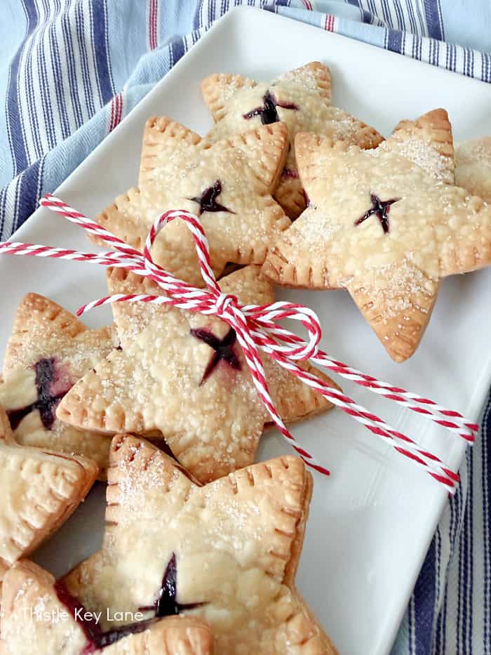 Baked goods on a tray with a red and white string bow. Star Blueberry Hand Pies Recipe.