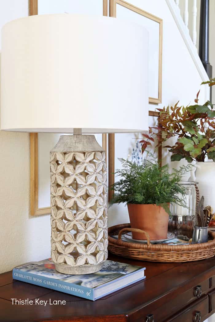 Neutral lamp and shade sitting on a book.